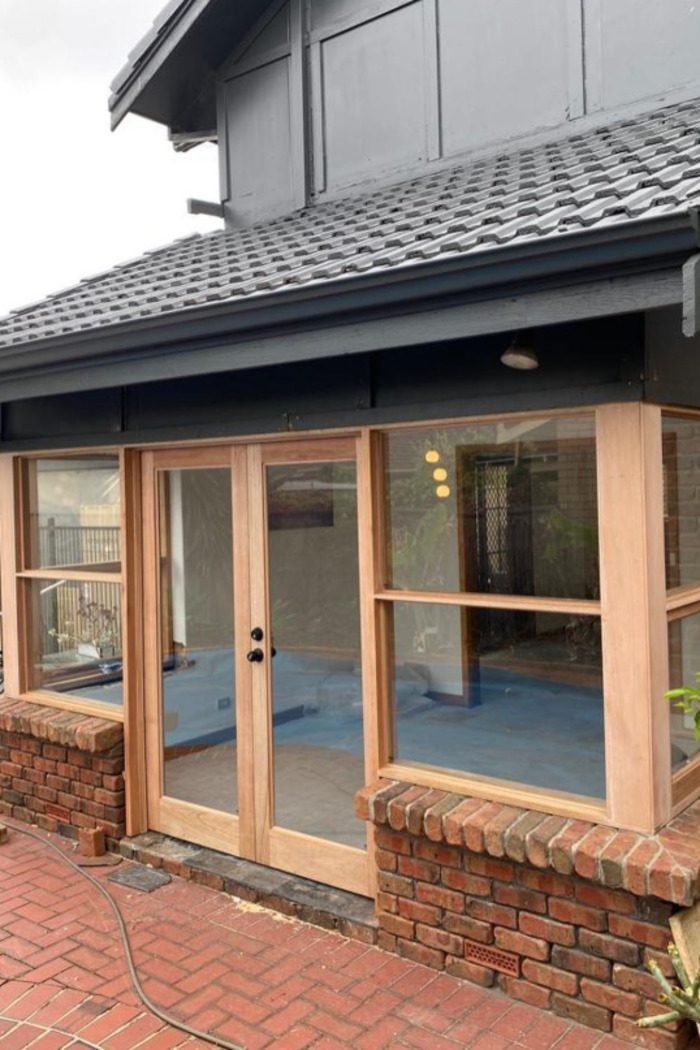 Timber-framed sunroom with French door and windows