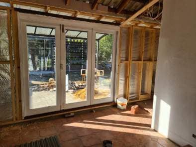 French-style hinged doors opening from a sunroom onto the back patio