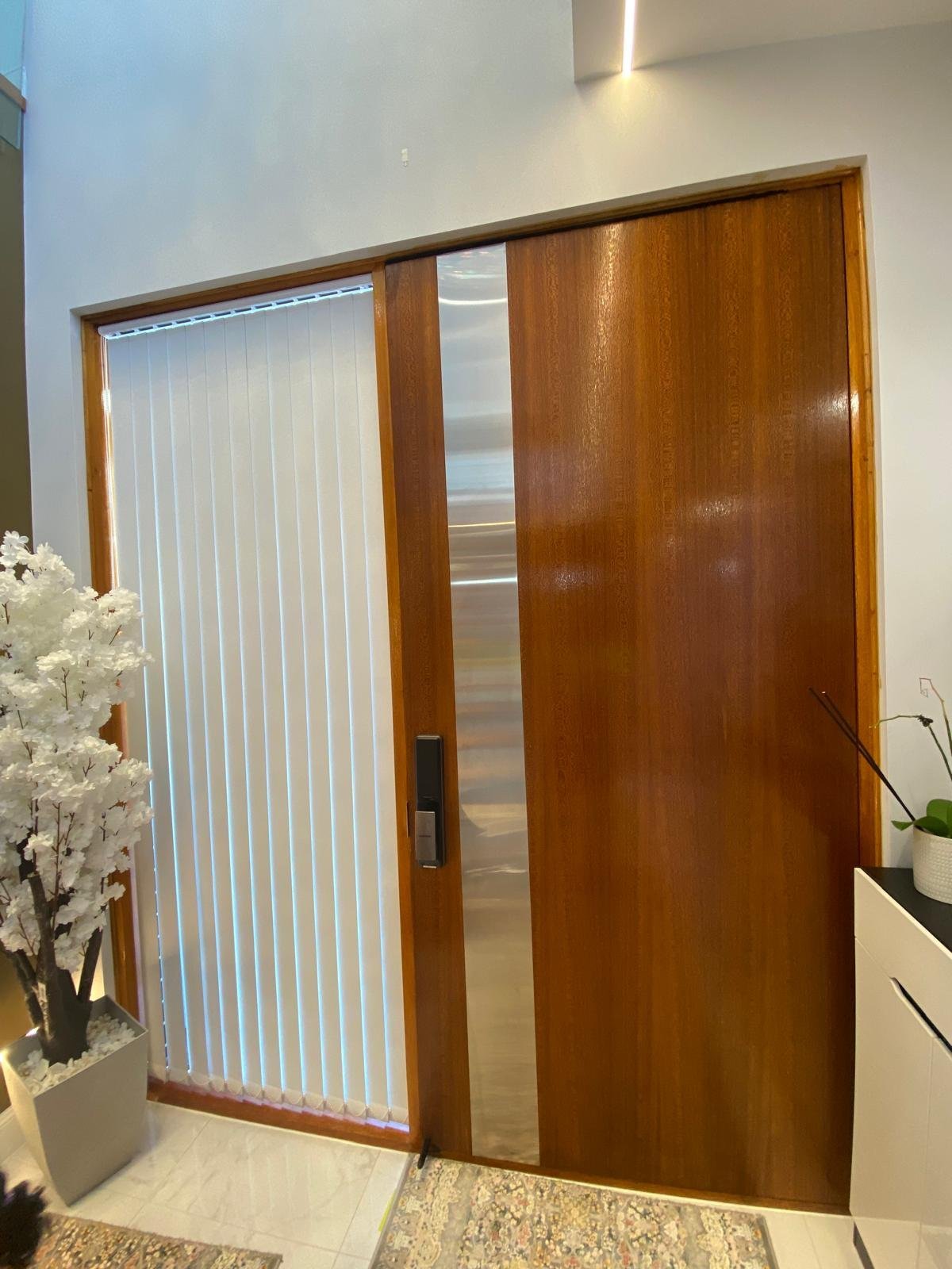 Timber sliding door with a stainless-steel accent panel, interior entryway