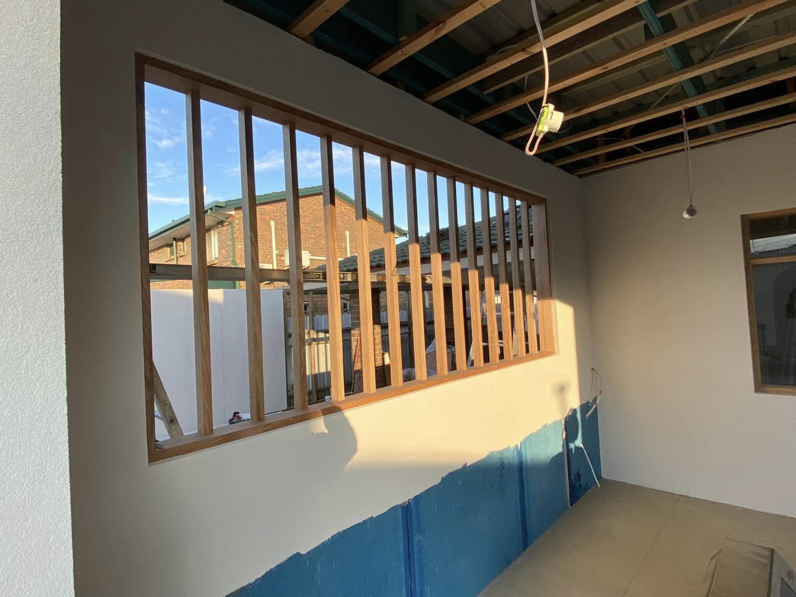 Vic Ash vertical slat window screen spanning a full-height alfresco wall opening